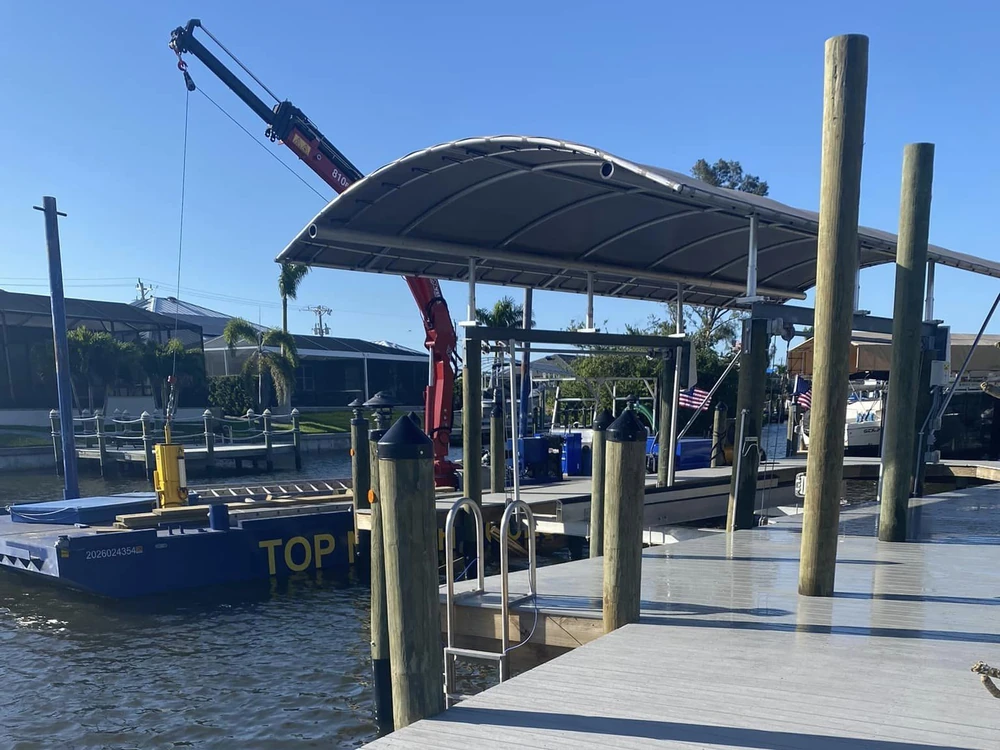 Marine construction crane and waterfront work | Top Notch Docks Top Notch Docks marine construction crane working beside a waterfront dock and boat lift