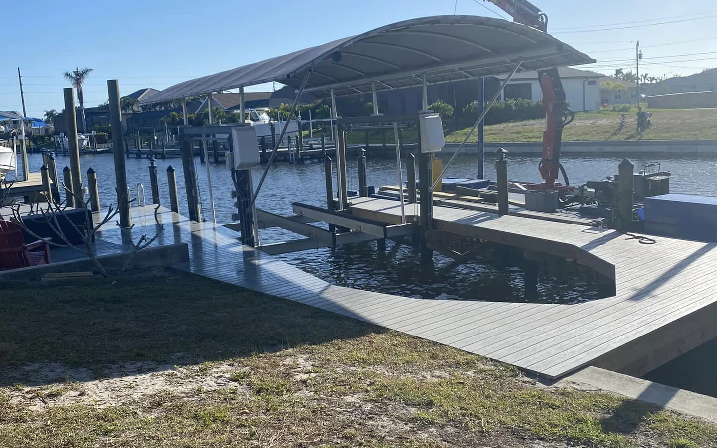 Cape Coral dock removal and marine structure tear-out | Top Notch Docks Crane positioned over an existing Cape Coral waterfront dock and covered marine structure during removal planning