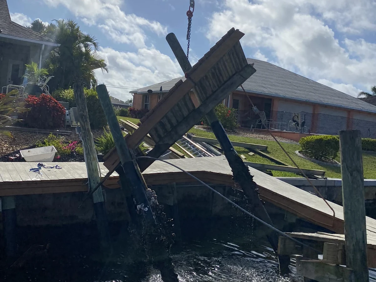 Damaged dock structure for repair versus replacement evaluation | Top Notch Docks Severely damaged dock structure lifted from the water during marine construction work