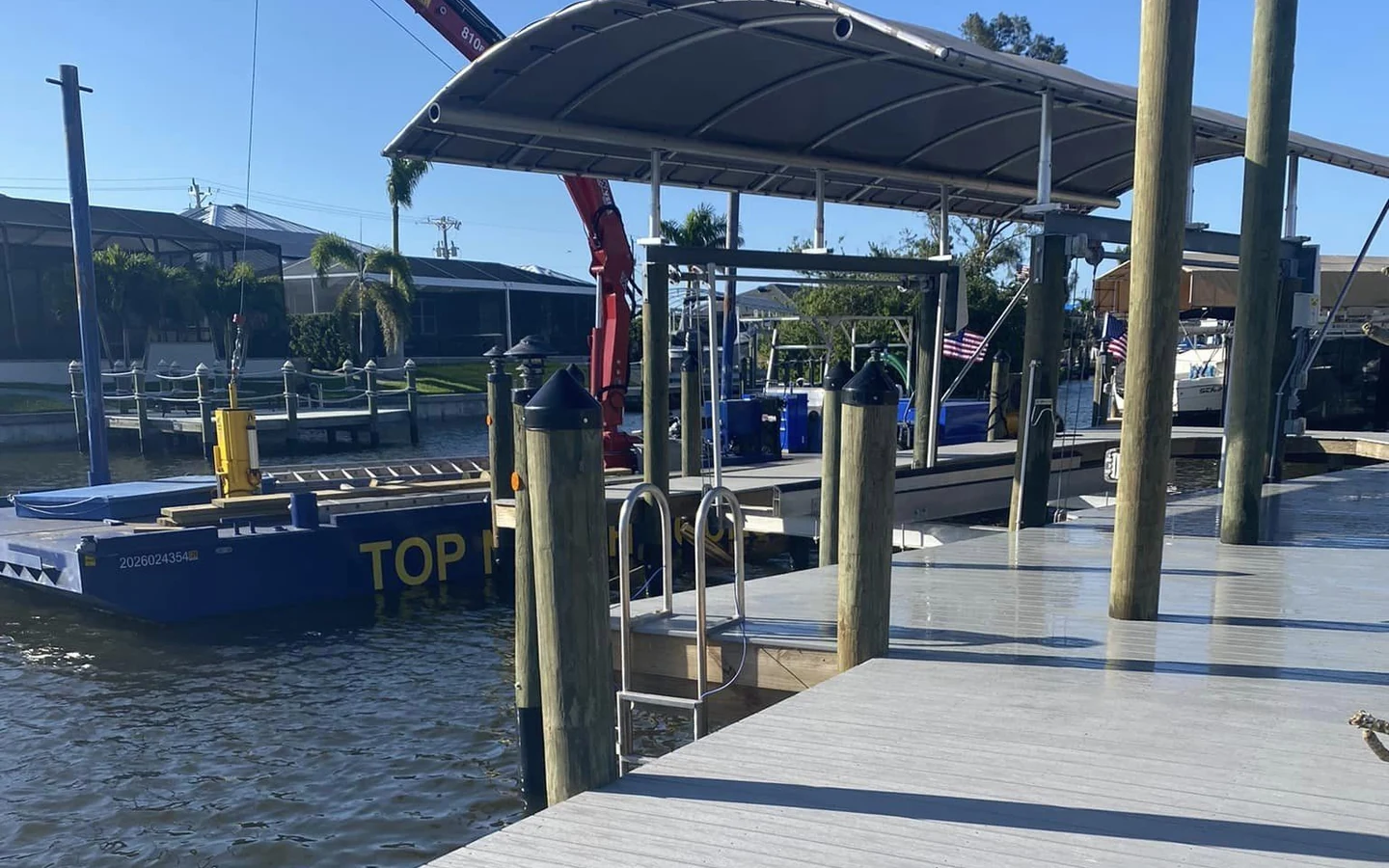 Cape Coral active dock repair work | Top Notch Docks Active waterfront work beside a Cape Coral dock during repair and restoration