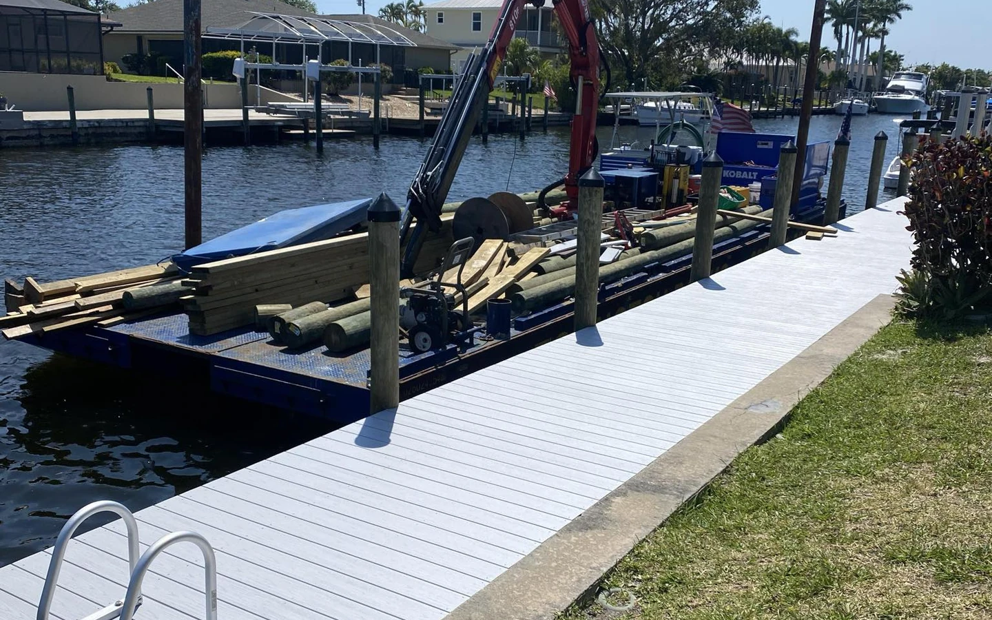 Top Notch Docks work barge and crane positioned beside a waterfront dock